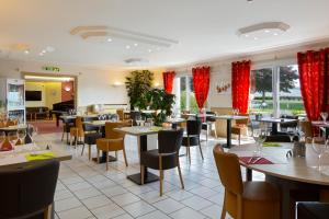 ein Restaurant mit Tischen und Stühlen und roten Vorhängen in der Unterkunft Logis Hotel Altina in Pacy-sur-Eure