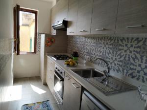 cocina pequeña con fregadero y fogones en Madar Home, en SantʼAgata sui Due Golfi