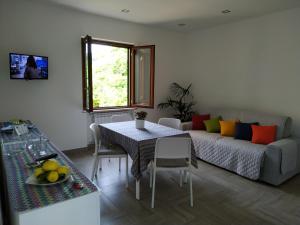 sala de estar con mesa y sofá en Madar Home, en SantʼAgata sui Due Golfi