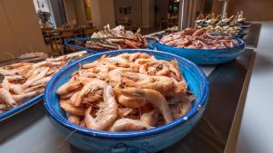 a bunch of lobsters in blue bowls on a counter at TUI Blue Isla Cristina Palace - Adults Recommended in Isla Cristina