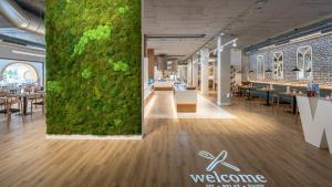 a large green wall in a restaurant with tables and chairs at TUI Blue Isla Cristina Palace - Adults Recommended in Isla Cristina