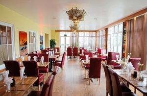 um restaurante com mesas e cadeiras e um lustre em La Trelade Hotel em St Martin Guernsey