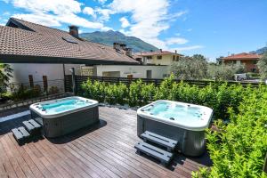 a hot tub sitting on top of a wooden deck at Villa degli Olivi Relais in Nago-Torbole