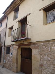 un edificio con una puerta y un balcón con flores. en Apartamentos Rurales Casa del Tio Juan, en Olocau del Rey