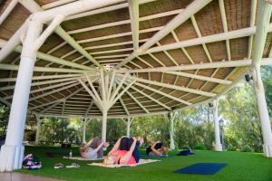 a group of people laying on the grass under a pavilion at TUI Blue Isla Cristina Palace - Adults Recommended in Isla Cristina