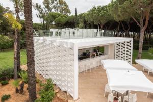 a white building with white tables and white chairs at TUI Blue Isla Cristina Palace - Adults Recommended in Isla Cristina