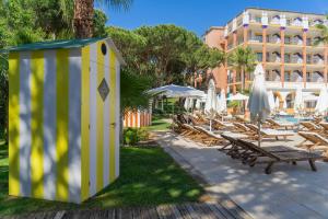 a yellow and white building with chairs and umbrellas at TUI Blue Isla Cristina Palace - Adults Recommended in Isla Cristina