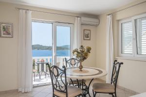 uma sala de jantar com uma mesa e cadeiras e uma janela em Kis Residence - Adults Only em Korčula