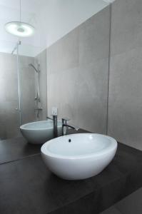 a white sink sitting under a mirror in a bathroom at Galeria River in Ljubljana