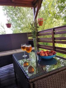 - une table avec deux verres de vin et un bol de fruits dans l'établissement Mazurska Niezapominajka, à Sajzy