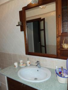 een badkamerbar met een wastafel en een spiegel bij Agriturismo A Veggia Vigna in Garlenda