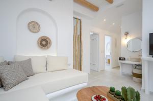 a white living room with a white couch and a table at Smirida Suites in Naxos Chora