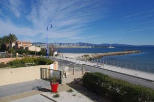 a view of a beach and the ocean with a street light at Les Stoechades in Hyères