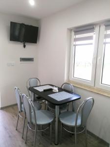 a dining room with a table and chairs and a tv at Bieszczadzki Orzeł in Berezka