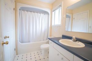 a bathroom with a sink and a toilet and a mirror at Susan's Villa in Niagara Falls