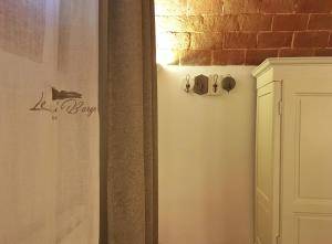 a bathroom with a white door and a brick wall at Le Camere Del Borgo in Montescudaio