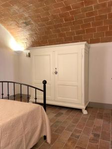 a bedroom with a bed and a brick wall at Le Camere Del Borgo in Montescudaio