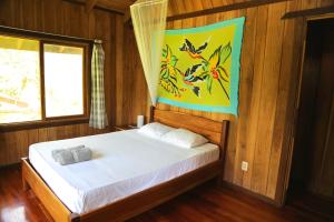 a bedroom with a bed with a painting on the wall at Hotel & Cabinas Nadine in Cahuita
