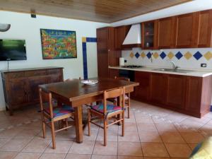 a kitchen with a wooden table and chairs and a sink at Chalet del Laghetto in Chiusa di Pesio