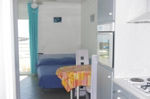a small kitchen with a small table and a bed at Les Stoechades in Hyères