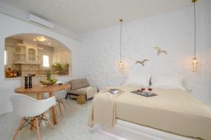 a bedroom with a bed and a table and a dining room at Smirida Suites in Naxos Chora