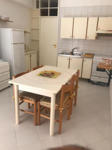 a kitchen with a white table and chairs in it at Casa Vacanze Ciullo d'Alcamo in San Vito lo Capo