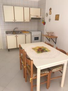 a kitchen with a table and chairs in a kitchen at Casa Vacanze Ciullo d'Alcamo in San Vito lo Capo