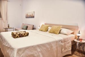 1 dormitorio con 1 cama blanca grande con almohadas amarillas en Apartments Casa Pineta, en Ulcinj