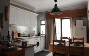 a kitchen with white cabinets and a washer and dryer at Lovely oceanview beach house in Portimão