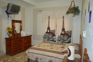 a bedroom with a bed and a dresser and a television at Hotel Colonial in Yautepec de Zaragoza