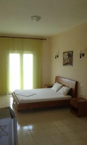 een slaapkamer met een groot bed en een raam bij Oasis Drymades Hotel in Dhërmi