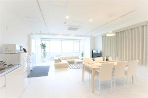 BIG ROOM GUEST HOUSE في أوساكا: غرفة طعام وغرفة معيشة مع طاولة وكراسي