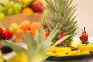 un plato de fruta con piña y otras frutas en Hotel Emmerich, en Winningen