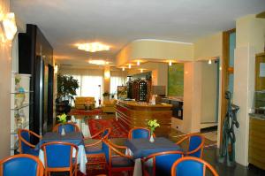 a room with tables and chairs and a living room at Hotel Côte D'Est in San Foca