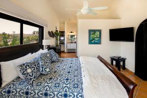 1 dormitorio con 1 cama grande con almohadas azules y blancas en La Marina Inn, en San José del Cabo