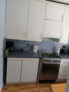 a kitchen with white cabinets and a stove at Dream Time Apartments-Aqua Suite in London