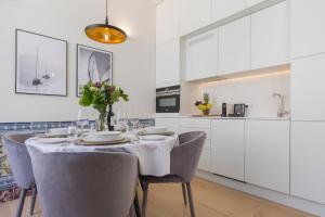 uma cozinha branca com mesa e cadeiras em Ando Living - Santa Justa 79 Townhouse em Lisboa