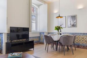 a dining room with a table with chairs and a tv at Ando Living - Santa Justa 79 Townhouse in Lisbon