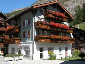 a building with flower boxes and balconies on it at Haus Wiedersehen, Mischabel (2-Zi) in Saas-Grund