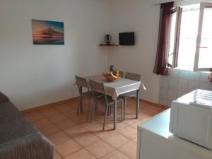 a kitchen with a table and chairs in a room at Apartments I-P in Malinska