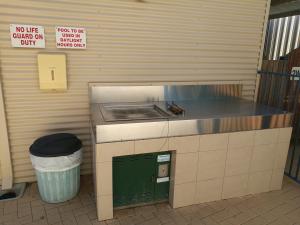 a public restroom with a toilet and a trash can at Kalbarri Edge Resort in Kalbarri