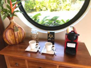 due tazze di caffè su un tavolo con specchio di Ocean Breeze Bungalow a Tevaitoa