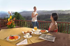 a couple of women sitting at a table with food at Ladera Hotel in Turrialba