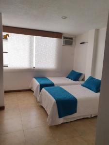 2 camas en una habitación con ventana en Departamento frente al mar en Manta-Barbasquillo con espectacular vista, en Manta