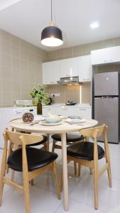 eine Küche mit einem Tisch und Stühlen sowie einem Kühlschrank in der Unterkunft Orangerabbit@IconCity in Petaling Jaya