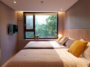 a bedroom with a large bed and a window at Hostel CLEO Seoul Hongdae in Seoul