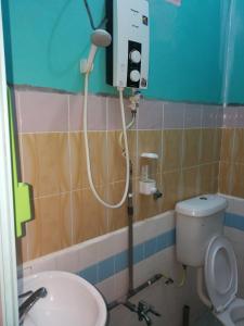 a bathroom with a toilet and a shower in it at Rainbow Tioman Cottage in Kampong Juara