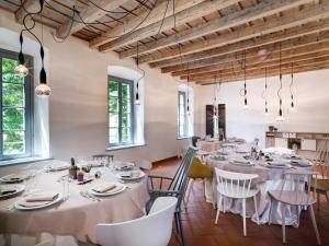 ein großes Esszimmer mit weißen Tischen und Stühlen in der Unterkunft Locanda Dei Nobili Viaggiatori in Cavernago