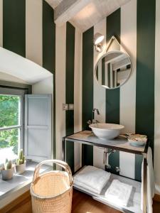 y baño con lavabo y paredes de rayas verdes y blancas. en Locanda Dei Nobili Viaggiatori, en Cavernago
