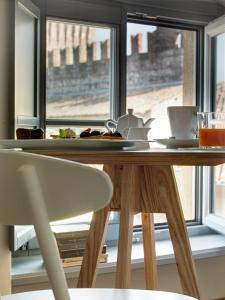 a wooden table with a chair in front of a window at Locanda Dei Nobili Viaggiatori in Cavernago